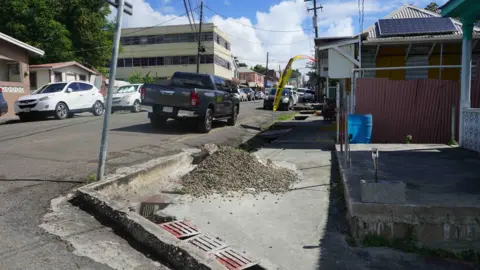 Gemma Handy A trotoar yang dipenuhi dengan batu dan lubang, serta trotoar tinggi, menunjukkan tantangan orang dengan masalah mobilitas yang terjadi di St John's