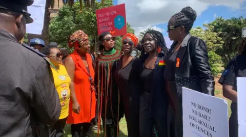 Sista d pengunjuk rasa wanita memegang plakat, yang berbunyi: tidak ada ikatan! Tidak ada jaminan! Untuk pelanggaran seksual. 