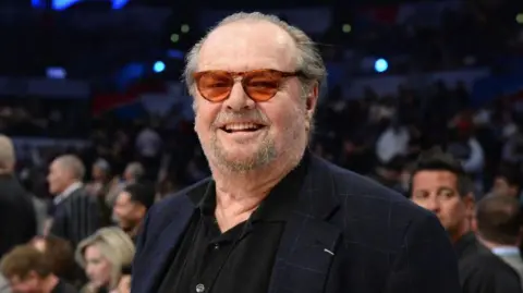 Getty Images Jack Nicholson berfoto di pertandingan NBA pada tahun 2018. Dia mengenakan jaket angkatan laut, kacamata hitam dan kacamata Tinted Toriseshell.