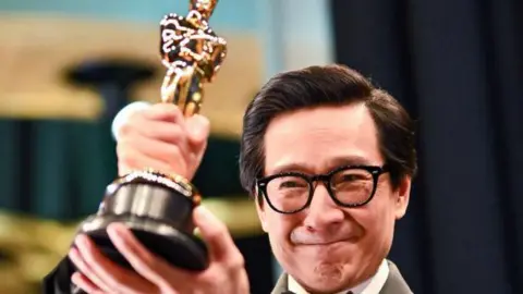 Getty Images Ke Huy Quan mengakhiri Hollywood - di sini ia memegang Oscar -nya untuk aktor pendukung terbaik tahun lalu.