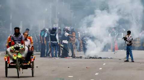 Reuters Smoke naik dari kebakaran yang ditetapkan di jalan selama protes oleh para siswa yang menuntut penurunan dari Perdana Menteri Bangladesh Sheikh Hasina, mengikuti protes reformasi kuota, di Dhaka, Bangladesh, 4 Agustus 2024.