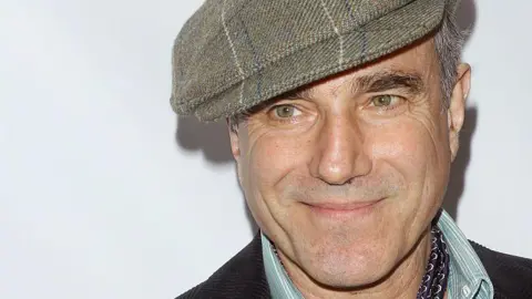 Getty Images Daniel Day-Lewis tersenyum dan mengenakan topi Tweed Baker Boy