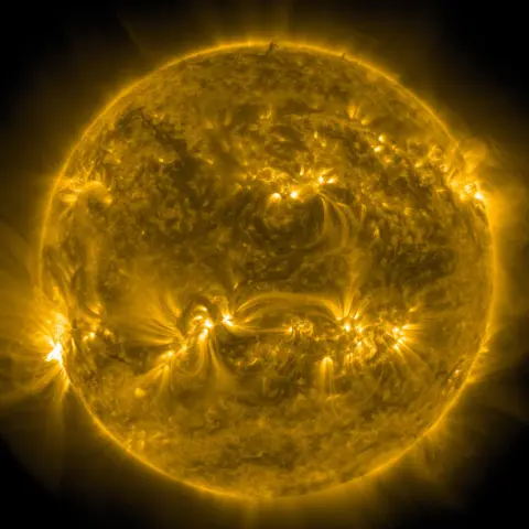Gambar Matahari NASA dari Solar Dynamics Observatory NASA, menunjukkan pola emas dan hitam yang bersinar di permukaan Matahari. 