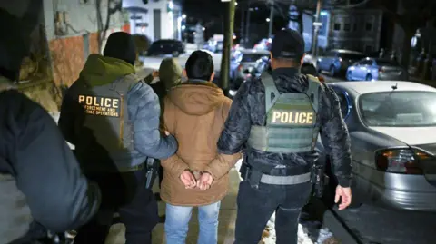 Getty Images Migran tidak berdokumen ditahan oleh petugas di New York City pada 28 Januari. 